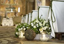 Allestimento floreale con fiori bianchi sfere e candele per la cerimonia