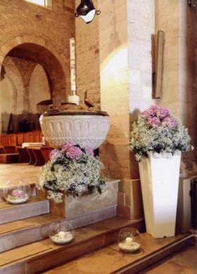 Addobbo floreale per la chiesa con vasi rotondi e candele