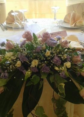 Addobbi floreali lilla per il tavolo degli sposi