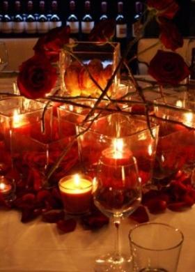 Centrotavola con rose rosse e candele per il tavolo degli sposi