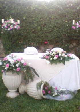 Il tavolo degli sposi con composizione di rose e anfore