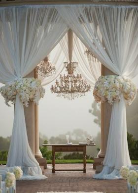 Allestimento con tende e fiori bianchi per un'atmosfera romantica