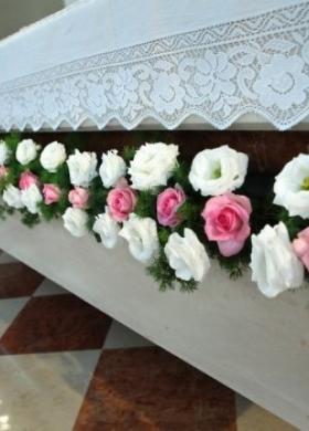 Addobbi floreali bianchi e rosa per l'altare della chiesa