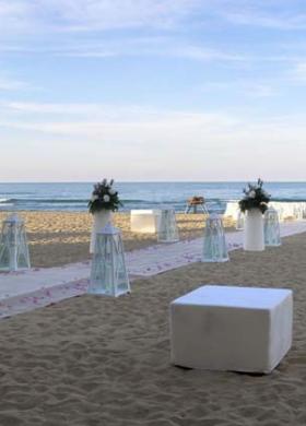 Decorazioni floreali con vasi di design per un matrimonio in spiaggia