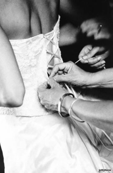 Le sarte aiutano la sposa a chiudere il corpetto dell'abito
