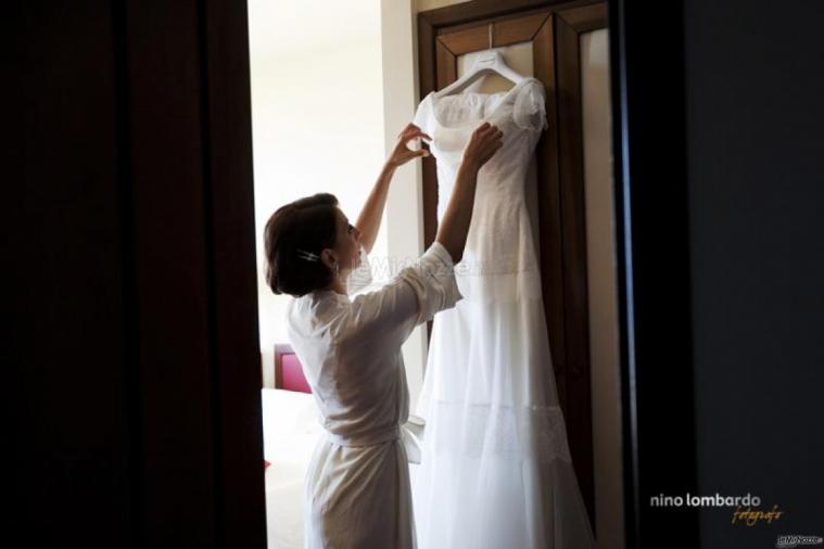 Nino Lombardo Fotografo - La sposa sta per indossare l'abito