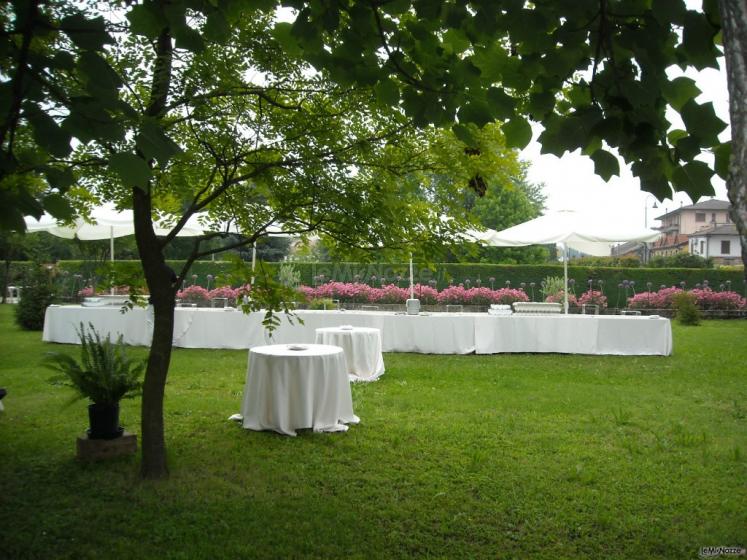 Allestimento tavoli per l'aperitivo di matrimonio in giardino