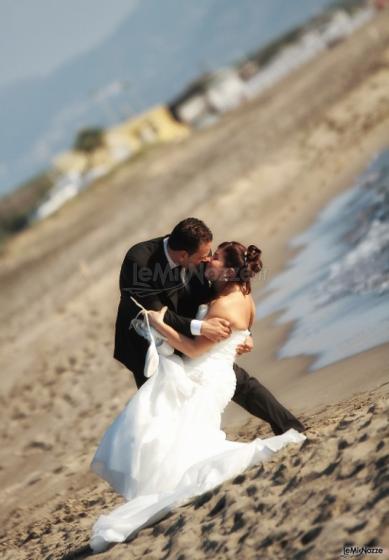 Foto del bacio degli sposi in riva al mare