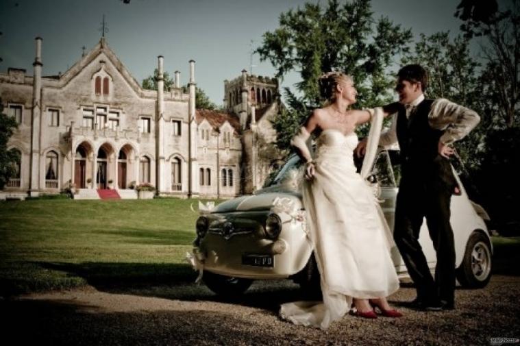 Sposi sulla macchina da cerimonia all'entrata del castello