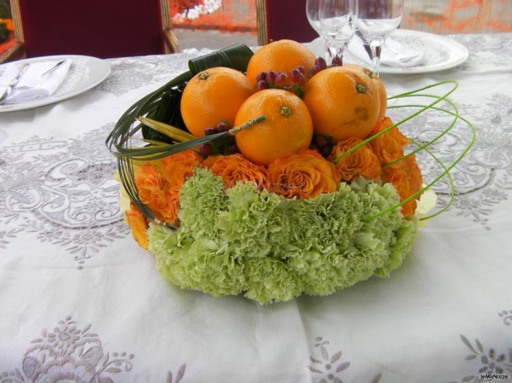 Composizione di arance e fiori per i tavoli di nozze