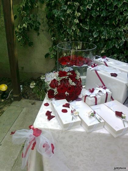 Il tavolo delle bomboniere con rose rosse