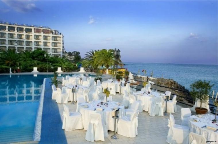 Allestimento dei tavoli a bordo piscina per il ricevimento di nozze