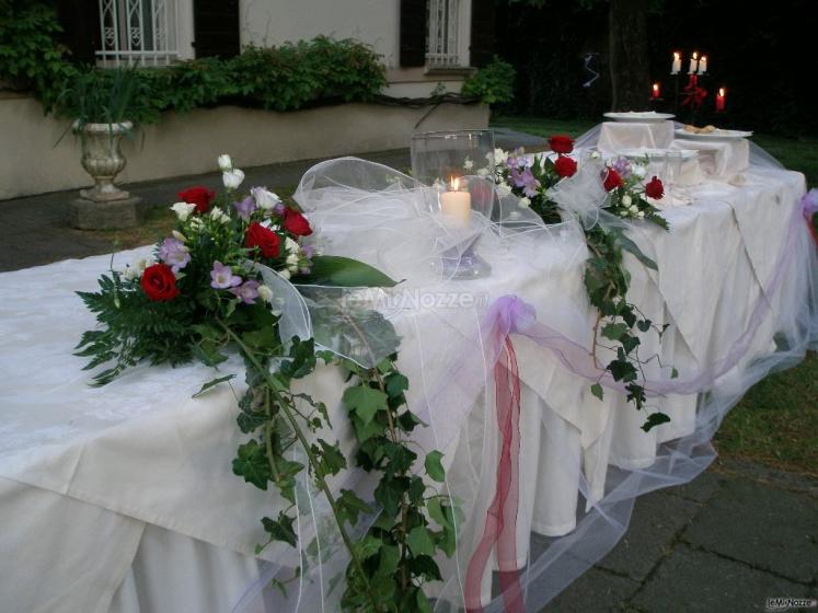 Allestimento con fiori, tulle e candele per il tavolo del buffet