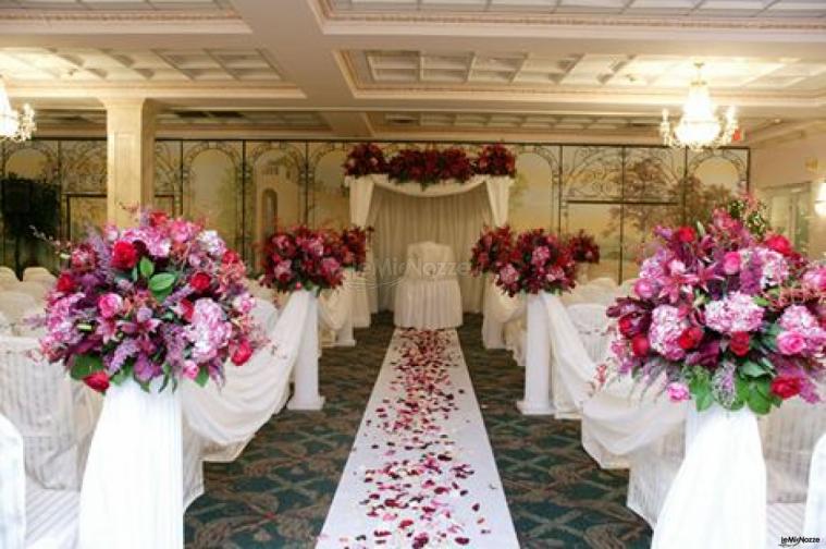 Addobbi floreali in rosa e petali sparsi per la cerimonia di nozze