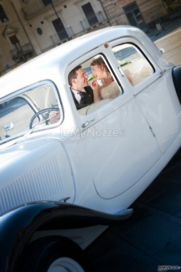 Foto degli sposi sorridenti nella macchina da cerimonia