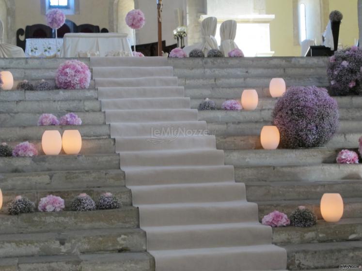 Composizione floreale lilla con sfere di fiori e candele