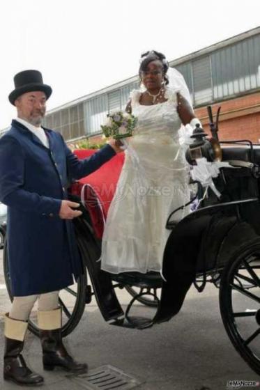 La sposa scende dalla carrozza aiutata dal cocchiere in livrea