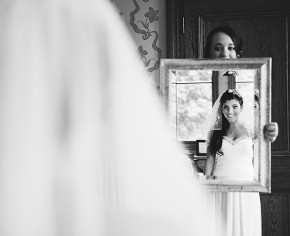 La sposa si guarda allo specchio con l'abito da sposa