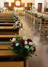 Decorazioni floreali rosse e bianche per i banchi della chiesa