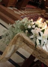 Fiori bianchi e candele per l'altare della chiesa