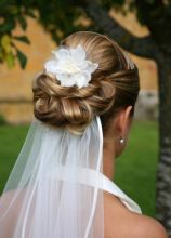 Chigon intrecciato con fiore per i capelli della sposa