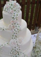 Torta multipiano con decorazione di rose che scende dall'alto