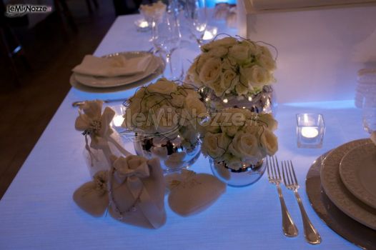 Sacchetti porta confetti per il matrimonio e vasi con rose bianche