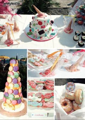 Dessert table-piramide di macarons, biscottini a forma di caramella e donuts