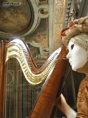 Arpa e musicista in maschera veneziana