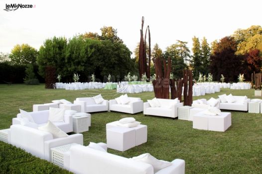 Allestimento di divanetti bianchi nel parco della villa