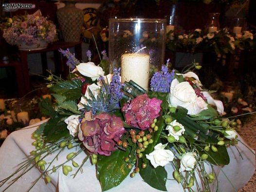 Composizione floreale con candela per il matrimonio