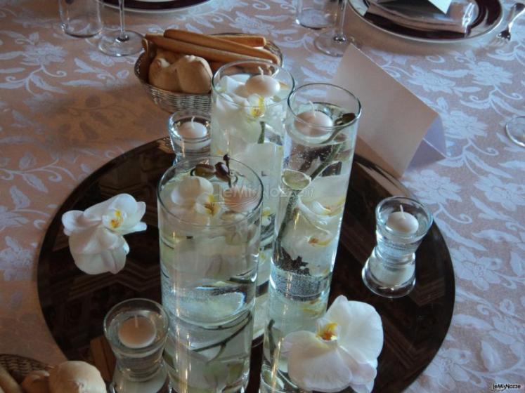Centrotavola con orchidee galleggianti, specchio e candeline