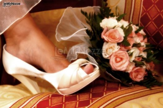 Fotografia con particolare delle scarpe e del bouquet della sposa