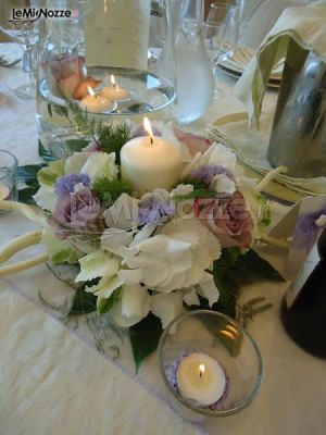 Centrotavola con fiori e candele per i tavoli di matrimonio