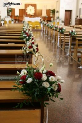 Decorazioni floreali rosse e bianche per i banchi della chiesa