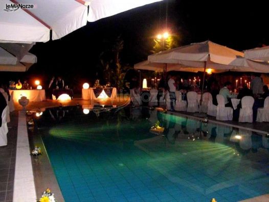 Allestimento tavoli per ricevimento di matrimonio a bordo piscina presso Villa Nettuno