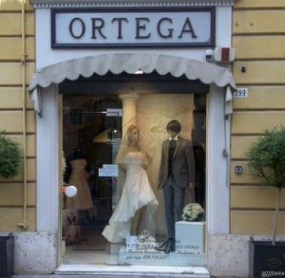 Pregiati abiti da sposa e da sposo esposti nella vetrina dell'Atelier Ortega Sposi