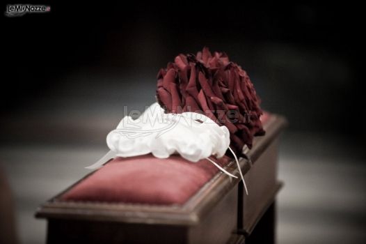 Foto del particolare del bouquet della sposa e del cuscino porta fedi nuziali