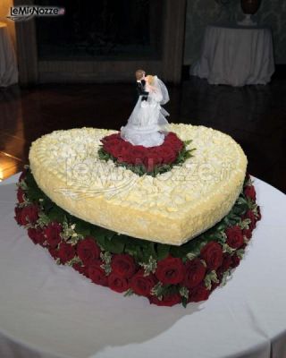 La torta di nozze a forma di cuore con rose rosse