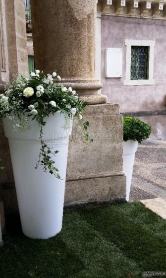 Allestimento matrimonio con vasi luminosi e piante verdi e fiorite.