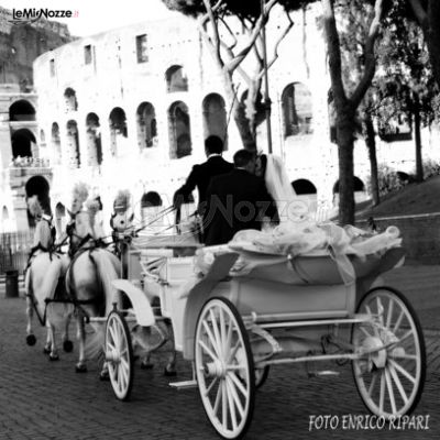 Gli sposi in carrozza trainata da una quadriglia di cavalli bianchi