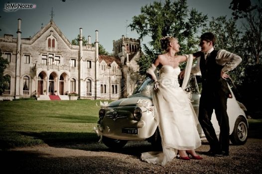 Sposi sulla macchina da cerimonia all'entrata del castello