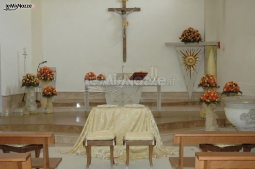 Addobbi chiesa con seduta sposi in avorio e fiori arancioni