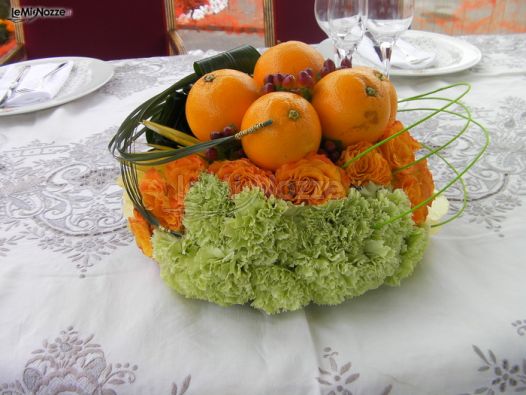 Composizione di arance e fiori per i tavoli di nozze