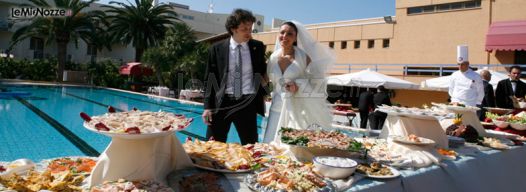 Gli sposi con il tavolo del buffet a bordo piscina - Il Brigantino Barletta