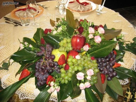 Centrotavola con fiori e frutta per il ricevimento di matrimonio