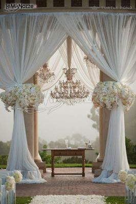 Allestimento con tende e fiori bianchi per un'atmosfera romantica