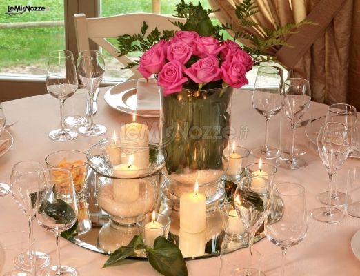 Centrotavola floreale con candele per il ricevimento di nozze