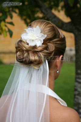 Chigon intrecciato con fiore per i capelli della sposa