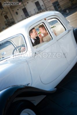 Foto degli sposi sorridenti nella macchina da cerimonia